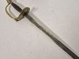a close up of a sword on a white surface with a black handle
