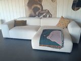 une photo d'un salon avec un canapé blanc et un tableau représentant un cheval accroché au mur
