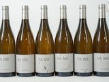 six bouteilles de vin sont alignées sur une table