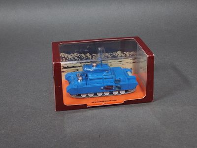 un petit char de jouet bleu dans une boîte transparente posée sur une surface grise