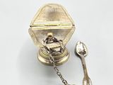 a silver spoon and spoon rest on a white surface