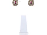 une paire de boucles d'oreilles en diamants roses et blancs, posée sur un présentoir