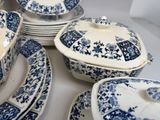 many blue and white plates and bowls on the table