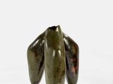 trois bananes vertes posées sur une surface blanche