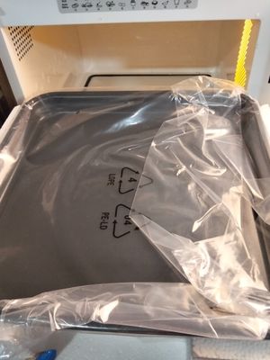 un sac en plastique posé sur un four à micro-ondes ouvert