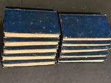 several blue books stacked on top of each other on a table