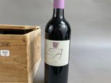 a bottle of wine sitting next to a wooden box