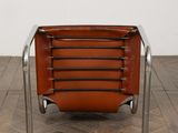 a brown leather chair sitting on top of a wooden floor