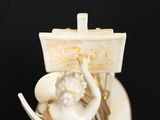 a figurine of a woman sitting on a boat