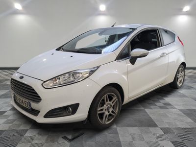 une Ford Fiesta blanche garée sur un sol à damier dans un garage