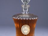 an old fashioned bottle of whiskey sitting on a white surface