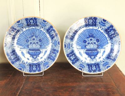 deux assiettes bleues et blanches posées sur une table en bois, avec un mur en arrière-plan