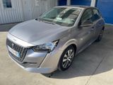 La voiture argentée est garée devant un garage bleu.