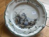 a plate with a painting on it sitting on a wooden floor