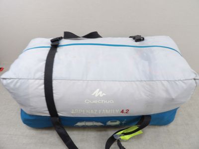 un sac de voyage blanc et bleu posé par terre