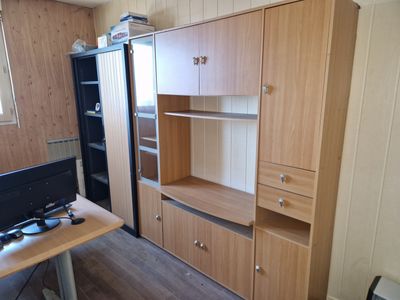 a desk with a computer and a cabinet in the room