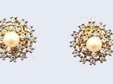 une paire de boucles d'oreilles en perles et diamants sur fond blanc