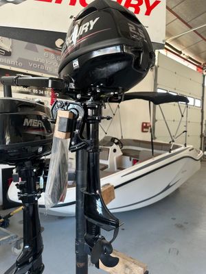 deux moteurs hors-bord posés sur un support dans un magasin de bateaux