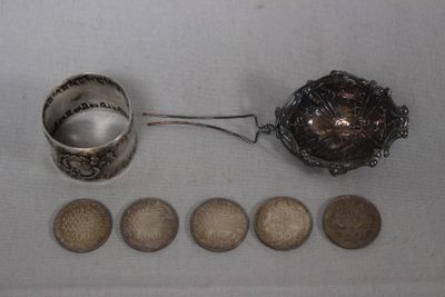 une cuillère en argent et quelques pièces de monnaie posées sur une table
