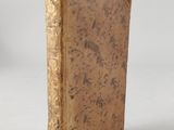 an old book sitting on top of a white surface