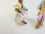 two figurines of people standing next to each other
