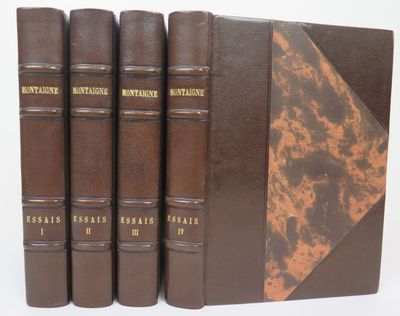 quatre livres marron sont alignés les uns à côté des autres sur une surface blanche