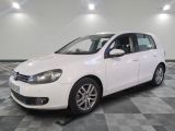 la volkswagen golf blanche est garée dans une pièce au sol en damier