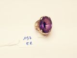 an amethorate ring with a purple stone surrounded by a gold band