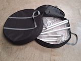 un sac noir posé par terre, contenant un jeu de baguettes