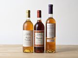 trois bouteilles de vin posées sur une table en bois