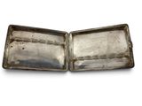 two silver trays with handles on a white surface
