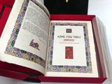 un livre ouvert posé dans une boîte rouge sur une table