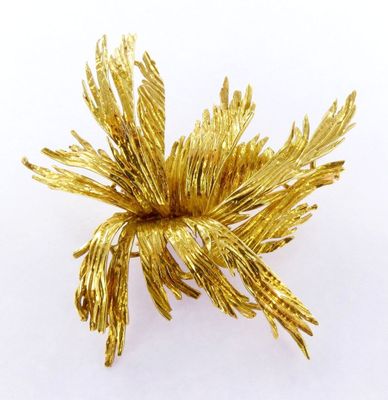 an image of a gold flower brooch on a white background