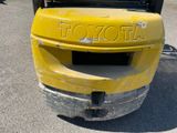 a yellow trash can sitting in a parking lot