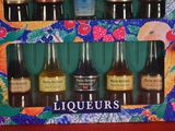 six bottles of liquor in a box on a table