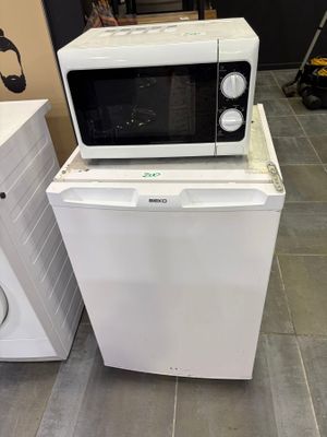 two microwaves sitting on top of each other on the floor