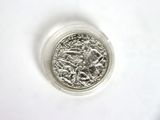 a close up of a silver coin on a white surface