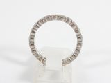 a close up of a diamond ring on a stand on a white surface