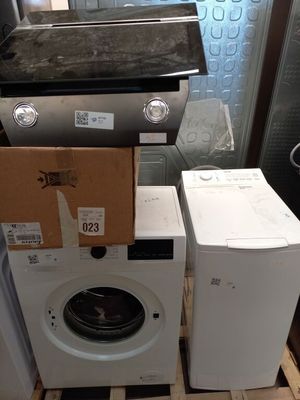 une pile d'appareils électroménagers posée sur une palette dans une pièce