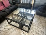 a coffee table with a glass top on a marble floor