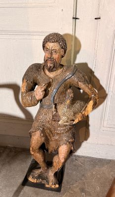 une statue représentant un homme tenant un chien dans ses bras