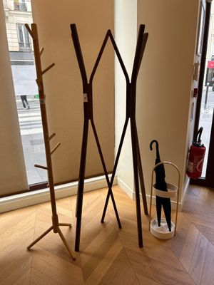 a coat rack and umbrella stand in the corner of a room