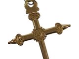 croix en métal plaqué or, au motif ouvragé, sur fond blanc