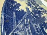 a blue and white plate with a picture of a house on it