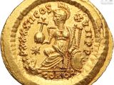 a close up of a gold coin with an image of a woman on it
