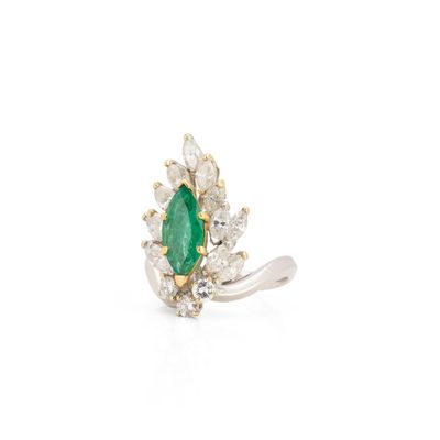gros plan d'une bague en émeraude et diamant sur fond blanc