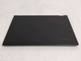 the back of a black laptop sitting on top of a white surface