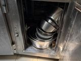stainless steel pots and pans are stacked on top of a kitchen counter
