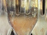 a lot of silver spoons that are sitting on a table