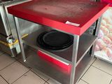 une table rouge sur laquelle est posée une assiette noire, dans une cuisine